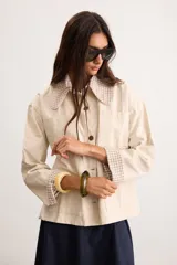 Sobrecamisa de algodón color beige con bolsillos frontales plaqué, cierre de botones y detalles de cuello y puños con estampado a cuadros vichy.