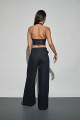 Jean de denim azul oscuro con diseño de tiro alto, piernas anchas de corte recto y costuras pespunteadas en contraste. Incluye un cinturón integrado con hebilla forrada y pasadores anchos.