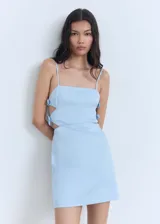 Vestido corto de algodón color celeste, con tirantes finos, escote recto y aberturas laterales decoradas con lazos.