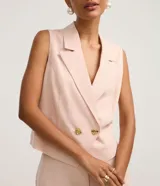 Chaleco femenino de sastrería color rosa pálido, con cuello blazer, cruce delantero con botones dorados y corte estructurado.