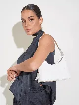 Cartera de fiesta blanca con efecto charol, asa corta y cierre superior.