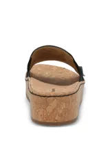 Sandalias Hush Puppies modelo Corla, color negro, con plataforma de corcho y capellada de cuero con detalle elástico lateral y etiqueta de la marca.