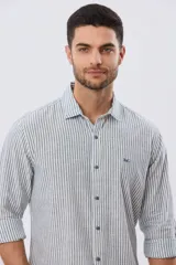 Camisa de manga larga confeccionada en mezcla de lino y algodón, con diseño de rayas verticales celestes y blancas. Presenta cuello camisero tradicional, cierre frontal con botones y sutil bordado del logo en el pecho.