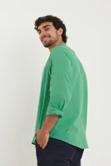 Camisa de cuello mao y manga larga, confeccionada en una mezcla de lino y algodón. Presenta un diseño de corte recto con botones en tono natural y un bolsillo pequeño en el pecho.