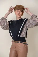 Buzo negro de lana fina con mangas largas abullonadas y laterales de seda con estampado animal print.