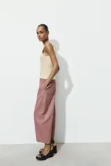 Pantalón de tiro alto con diseño tipo ballon, bolsillos laterales ocultos en costura y cierre frontal con cremallera y botón.
