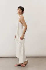 Vestido largo negro de corte al cuerpo con cuello halter y detalle de hebilla metálica dorada en el hombro con tira drapeada.