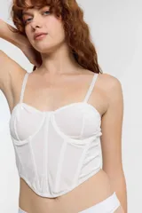 Corset blanco con tirantes finos y corte bajo el busto.
