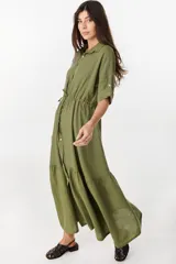 Vestido camisero largo de lino italiano color celeste, de corte relajado, con mangas caídas, jareta ajustable en la cintura, cierre frontal de botones y bajo con volado fruncido.