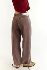 Pantalón de jean de tiro bajo, color marrón con efecto lavado, de corte recto y holgado. Presenta cordones de ajuste en los tobillos para modificar la silueta y bolsillos laterales.