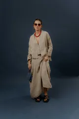 Chaqueta de lino color beige, de calce relajado, con escote en V, cierre frontal con botones y bolsillos delanteros.