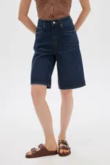 Bermuda de jean azul de tiro alto, corte boyfriend con bolsillos y terminaciones deshilachadas.