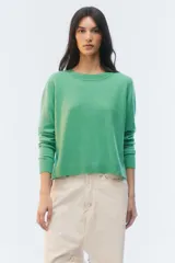Sweater de tejido de punto verde, con calce regular levemente suelto, escote redondo y mangas largas con puños acanalados.