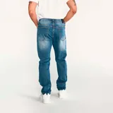 Jeans de hombre, corte slim, color azul claro desgastado (light stone). Presenta cierre de cremallera y botón con logo CAT, diseño de cinco bolsillos y costuras en tono naranja.