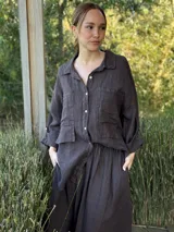 Camisa negra de manga larga con cuello clásico y cierre frontal con botones.