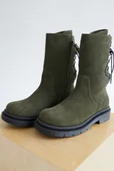 Botas de caña media color marrón, con cordones en la parte trasera y cierre lateral con cremallera.