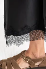 Falda midi negra de acabado satinado, corte al bies, con detalle de encaje en el ruedo.