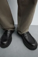 Mocasín de vestir de cuero negro, con antifaz y suela track.