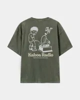 Remera oversize verde militar con efecto acid wash, mangas cortas y estampa gráfica en la espalda con diseño de dibujo animado y la inscripción "Kaboa Radio".