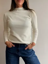 Media polera de tejido fino y acanalado, con cuello alto y manga larga, de calce ajustado al cuerpo.