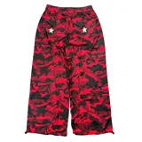 Pantalón de tiro bajo con estampado de camuflaje en tonos rojos y negros. Presenta diseño holgado, detalles de estrellas blancas aplicadas, paneles laterales con franjas verticales y bolsillos cargo.
