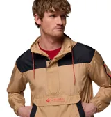 Chaqueta cortavientos Columbia modelo Challenger Windbreak Omni-Shield, en color beige con detalles en negro y costuras en rojo. Cuenta con capucha ajustable, cierre frontal de media cremallera, bolsillo canguro central con solapa y logo bordado, además de un bolsillo con cremallera en la manga izquierda.