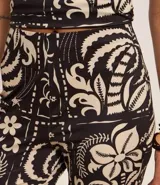 Mono strapless con estampado floral, corte ajustado en el torso y pantalón acampanado.
