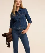 Pantalón de jean azul, corte slim, con trabillas en la cintura, bolsillos, cierre delantero tradicional y abertura en el bajo.