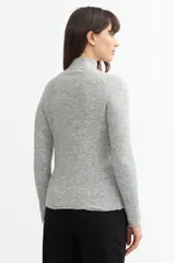 Sweater gris de punto con cuello alto y mangas largas.