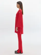 Pantalón negro de corte flare, con aberturas en el ruedo y cintura con elástico.