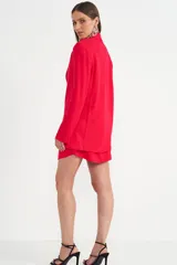 Blazer fucsia con solapa de muesca, hombreras marcadas y un único botón frontal. Incluye dos bolsillos de parche en la parte delantera.