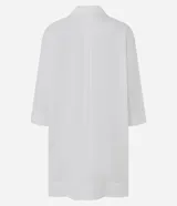 Salida de playa tipo túnica camisera blanca, con mangas 3/4, cuello camisero y cierre frontal con botones. Confeccionada en algodón certificado BCI.
