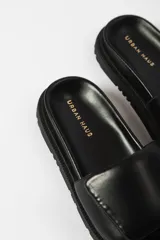 Sandalia tipo slide color fucsia, con suela track de plataforma y tira ancha acolchada en el empeine.