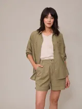 Camisa de algodón y lino color verde militar, de corte holgado, mangas largas con trabilla para arremangar, bolsillos plaqué en el pecho y cierre frontal con botones.