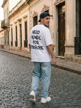 Remera blanca de corte oversize con estampa en la espalda con la frase "Need Money For Porsche" en color negro.