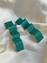 Par de aros colgantes con forma geométrica irregular, recubiertos de strass negros sobre base plateada.