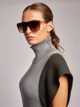 Vestido midi de tejido acanalado con cuello alto, sin mangas y diseño bicolor en tonos beige y terracota. Incluye un lazo ajustable en la cintura para entallar la silueta.