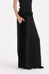 Pantalon de corte amplio y fluido, confeccionado en una combinación de terciopelo y tela satinada, con diseño elegante y tiro alto.