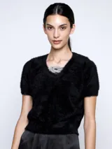 Sweater negro de mangas cortas con detalle de adorno brillante en el cuello.