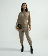 Pantalón jogger Marfinno color beige, confeccionado en suedine con cintura elástica y cordón ajustable. Presenta detalles perforados en los bolsillos laterales y en las costuras laterales, además de puños elásticos en los tobillos.