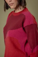 Buzo de punto con diseño abstracto que simula un paisaje, cuello redondo y mangas largas. Confeccionado en lana, presenta una combinación de colores en tonos beige, celeste y gris.