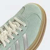 Championes Adidas Gazelle Bold color verde agua con detalles plateados y suela de plataforma marrón. Confeccionados en gamuza, cuero y material sintético.