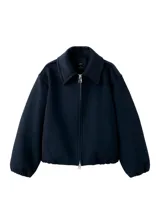 Chaqueta de corte amplio y estructurado en color negro, con cuello solapa, cierre frontal de cremallera metálica y bolsillos laterales discretos.
