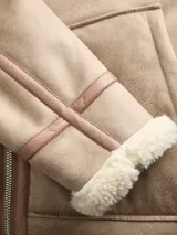 Campera estilo aviador color beige con forro interno y cuello de corderito sintético. Presenta cierre frontal bidireccional, mangas largas y terminaciones con puños y ruedo en corderito.