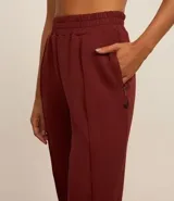 Pantalón jogger color borgoña, confeccionado en microfibra, con cintura elástica y frisos laterales.