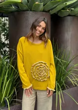 Sweater azul con diseño de flor en el frente y detalles de volados en puños y ruedo.