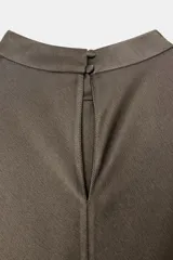 Vestido midi satinado de cuello subido y manga corta tipo capa. Presenta aberturas laterales con aplicación de encaje a tono y bajo asimétrico con detalle de encaje. Incluye un pañuelo integrado en el mismo tejido y cierre posterior con botones forrados.