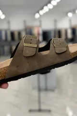Sandalia marrón con diseño de dos tiras ajustables con hebillas metálicas y plantilla anatómica.