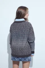 Sweater de tejido de punto con diseño de rayas horizontales en tonos bordó y celeste. Presenta cuello redondo, corte holgado y mangas largas con puños ajustados.