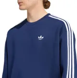Buzo Adidas de cuello redondo en color azul, con diseño oversize y ajuste relajado. Presenta el logo Trefoil bordado en el pecho y las icónicas tres tiras blancas en las mangas.